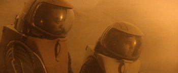 Movie still from “Star Trek II: The Wrath of Khan” (1982), directed by Nicholas Meyer – Two people in spacesuits are standing next to each other; Medium shot, Low angle