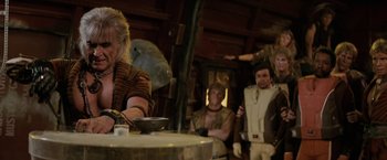 Movie still from “Star Trek II: The Wrath of Khan” (1982), directed by Nicholas Meyer – A group of people standing around a wooden table; Medium shot, Over the shoulder angle