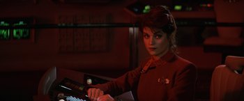 Movie still from “Star Trek II: The Wrath of Khan” (1982), directed by Nicholas Meyer – A woman in a red shirt is playing a keyboard; Close Up shot, Over the shoulder angle