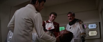 Movie still from “Star Trek II: The Wrath of Khan” (1982), directed by Nicholas Meyer – A group of men standing next to each other in a room; Medium shot, Over the shoulder angle