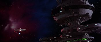 Movie still from “Star Trek II: The Wrath of Khan” (1982), directed by Nicholas Meyer – A view of a space ship from the ground up at night time; Extreme Wide shot, Low angle