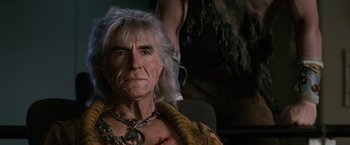 Movie still from “Star Trek II: The Wrath of Khan” (1982), directed by Nicholas Meyer – An older man with a chain around his neck; Close Up shot, Over the shoulder angle