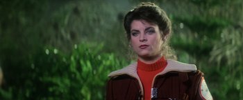 Movie still from “Star Trek II: The Wrath of Khan” (1982), directed by Nicholas Meyer – A woman in a red sweater is standing in front of trees; Close Up shot, Over the shoulder angle