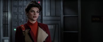 Movie still from “Star Trek II: The Wrath of Khan” (1982), directed by Nicholas Meyer – A woman in a red and brown jacket standing next to a door; Close Up shot, Over the shoulder angle