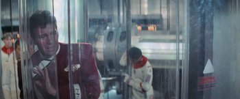 Movie still from “Star Trek II: The Wrath of Khan” (1982), directed by Nicholas Meyer – A man in a spacesuit is looking at something in a mirror; Medium shot, Over the shoulder angle