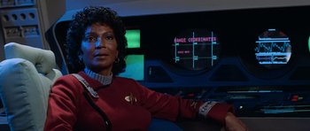 Movie still from “Star Trek III: The Search for Spock” (1984), directed by Leonard Nimoy – A woman in a red shirt is sitting in front of a computer screen; Close Up shot, Low angle