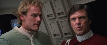 Movie still from “Star Trek III: The Search for Spock” (1984), directed by Leonard Nimoy – Two men standing next to each other in front of a wall; Close Up shot, Over the shoulder angle