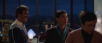 Movie still from “Star Trek III: The Search for Spock” (1984), directed by Leonard Nimoy – A man wearing a suit and a green scarf; Medium shot, Over the shoulder angle