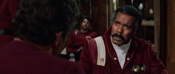 Movie still from “Star Trek III: The Search for Spock” (1984), directed by Leonard Nimoy – A man in a red jacket is talking to another man in a red jacket; Close Up shot, Over the shoulder angle