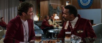 Movie still from “Star Trek III: The Search for Spock” (1984), directed by Leonard Nimoy – Two men sitting at a table with drinks and food; Medium shot, Over the shoulder angle