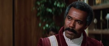 Movie still from “Star Trek III: The Search for Spock” (1984), directed by Leonard Nimoy – A man that is wearing a red and white suit; Close Up shot, Low angle