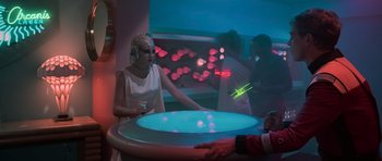 Movie still from “Star Trek III: The Search for Spock” (1984), directed by Leonard Nimoy – A woman in a white dress is standing in front of a table; Medium shot, Over the shoulder angle