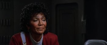 Movie still from “Star Trek III: The Search for Spock” (1984), directed by Leonard Nimoy – An older woman in a red jacket looking to her left; Close Up shot, Over the shoulder angle