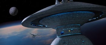 Movie still from “Star Trek III: The Search for Spock” (1984), directed by Leonard Nimoy – An image of an airplane flying in the sky near a building; Extreme Wide shot, Low angle