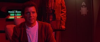 Movie still from “Star Trek III: The Search for Spock” (1984), directed by Leonard Nimoy – A man sitting in front of another man in a red room; Close Up shot, Over the shoulder angle