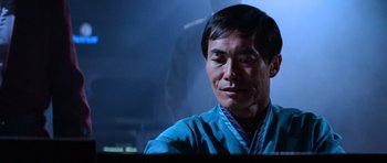 Movie still from “Star Trek III: The Search for Spock” (1984), directed by Leonard Nimoy – A man in a blue shirt is sitting in front of a computer screen; Close Up shot, Low angle