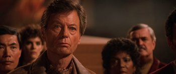 Movie still from “Star Trek III: The Search for Spock” (1984), directed by Leonard Nimoy – A person wearing a suit and tie; Close Up shot, Over the shoulder angle
