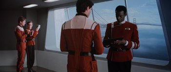 Movie still from “Star Trek IV: The Voyage Home” (1986), directed by Leonard Nimoy – Two men in red and white uniforms stand next to each other; Medium shot, Over the shoulder angle