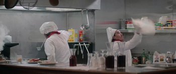 Movie still from “Star Trek IV: The Voyage Home” (1986), directed by Leonard Nimoy – A person in a kitchen with a lot of glasses on the table; Medium shot, Low angle