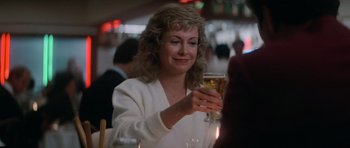 Movie still from “Star Trek IV: The Voyage Home” (1986), directed by Leonard Nimoy – A woman sitting at a table holding a glass of beer; Close Up shot, Low angle