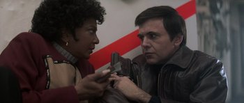 Movie still from “Star Trek IV: The Voyage Home” (1986), directed by Leonard Nimoy – A man and a woman looking at a cell phone; Close Up shot, Over the shoulder angle