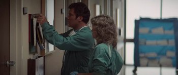 Movie still from “Star Trek IV: The Voyage Home” (1986), directed by Leonard Nimoy – A man and a woman in green scrubs looking out a window; Medium shot, Low angle