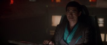 Movie still from “Star Trek IV: The Voyage Home” (1986), directed by Leonard Nimoy – A man sitting at a desk in a dark room; Medium shot, Over the shoulder angle