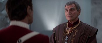 Movie still from “Star Trek IV: The Voyage Home” (1986), directed by Leonard Nimoy – A man in a red and purple suit is talking to another man in a red and purple suit; Close Up shot, Over the shoulder angle