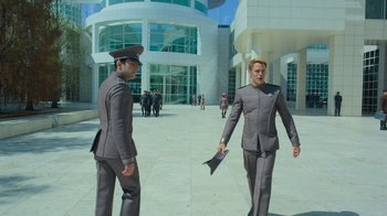 Movie still from “Star Trek Into Darkness” (2013), directed by J.J. Abrams – Two men dressed in grey suits stand in front of a building; Wide shot, Low angle