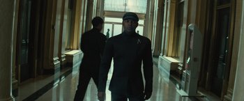 Movie still from “Star Trek Into Darkness” (2013), directed by J.J. Abrams – A man in a black suit is walking down a hall way; Medium shot, Low angle