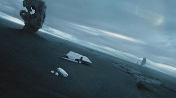 Movie still from “Star Trek Into Darkness” (2013), directed by J.J. Abrams – A person standing on a beach next to an object; Extreme Wide shot, Low angle