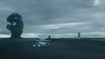 Movie still from “Star Trek Into Darkness” (2013), directed by J.J. Abrams – Two people sitting on the ground next to an airplane in a field; Extreme Wide shot, Low angle