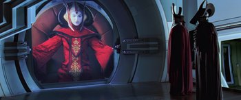 Movie still from “Star Wars: Episode I - The Phantom Menace” (1999), directed by George Lucas – A woman in a red dress is standing in front of a painting; Medium shot, Over the shoulder angle