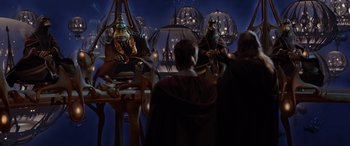 Movie still from “Star Wars: Episode I - The Phantom Menace” (1999), directed by George Lucas – A group of people standing in front of a stage; Wide shot, Over the shoulder angle