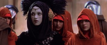 Movie still from “Star Wars: Episode I - The Phantom Menace” (1999), directed by George Lucas – Two women dressed up in different costumes and headpieces; Close Up shot, Over the shoulder angle