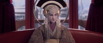 Movie still from “Star Wars: Episode I - The Phantom Menace” (1999), directed by George Lucas – A woman wearing a headdress and a brown robe; Close Up shot, Over the shoulder angle