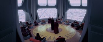 Movie still from “Star Wars: Episode I - The Phantom Menace” (1999), directed by George Lucas – A group of people sitting in a circle in front of a window; Extreme Wide shot, High angle