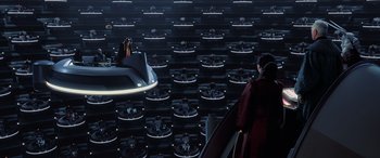 Movie still from “Star Wars: Episode I - The Phantom Menace” (1999), directed by George Lucas – A woman standing on top of an escalator in front of a wall; Extreme Wide shot, High angle
