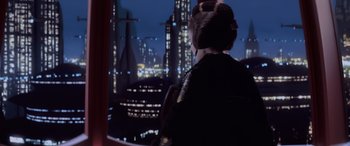 Movie still from “Star Wars: Episode I - The Phantom Menace” (1999), directed by George Lucas – A woman looking out over a city at night; Medium shot, Over the shoulder angle