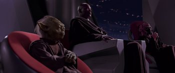 Movie still from “Star Wars: Episode I - The Phantom Menace” (1999), directed by George Lucas – A man sitting next to another man on a chair; Medium shot, High angle