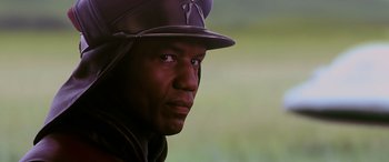 Movie still from “Star Wars: Episode I - The Phantom Menace” (1999), directed by George Lucas – A person wearing a hat; Close Up shot, Over the shoulder angle