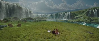Movie still from “Star Wars: Episode II - Attack of the Clones” (2002), directed by George Lucas – Two people sitting in the grass near a waterfall; Extreme Wide shot, High angle