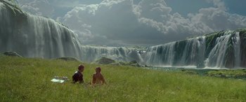 Movie still from “Star Wars: Episode II - Attack of the Clones” (2002), directed by George Lucas – Two people sitting in the grass near a waterfall; Extreme Wide shot, Low angle