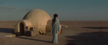 Movie still from “Star Wars: Episode II - Attack of the Clones” (2002), directed by George Lucas – A woman standing in front of a building in the middle of a desert; Wide shot, Low angle