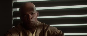 Movie still from “Star Wars: Episode II - Attack of the Clones” (2002), directed by George Lucas – A bald man in a brown jacket is sitting in front of a window; Close Up shot, Over the shoulder angle