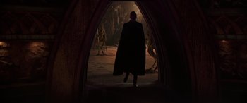 Movie still from “Star Wars: Episode II - Attack of the Clones” (2002), directed by George Lucas – A man wearing a cape walking through an archway; Wide shot, Over the shoulder angle