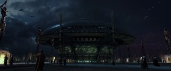 Movie still from “Star Wars: Episode II - Attack of the Clones” (2002), directed by George Lucas – People are standing in front of a building at night; Extreme Wide shot, Low angle