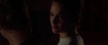 Movie still from “Star Wars: Episode II - Attack of the Clones” (2002), directed by George Lucas – A woman is looking at the camera in the dark; Close Up shot, Over the shoulder angle