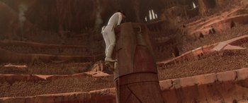 Movie still from “Star Wars: Episode II - Attack of the Clones” (2002), directed by George Lucas – A man climbing a pillar in an open area; Extreme Wide shot, Low angle