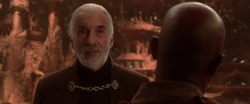 Movie still from “Star Wars: Episode II - Attack of the Clones” (2002), directed by George Lucas – An older man wearing a chain around his neck looking into a mirror; Close Up shot, Over the shoulder angle